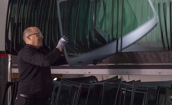 A man takes a windshield glass from his stock