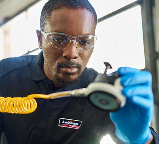 A man repairs a windshield at Lebeau