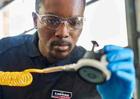 A man repairs a windshield at Lebeau