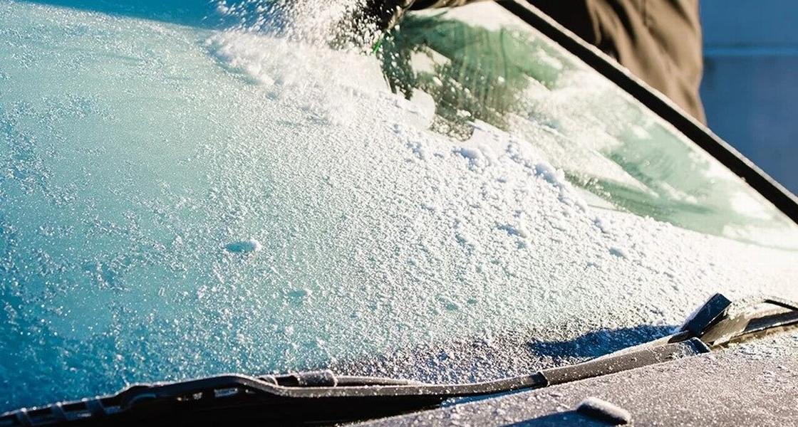 A person defrosts a windshield